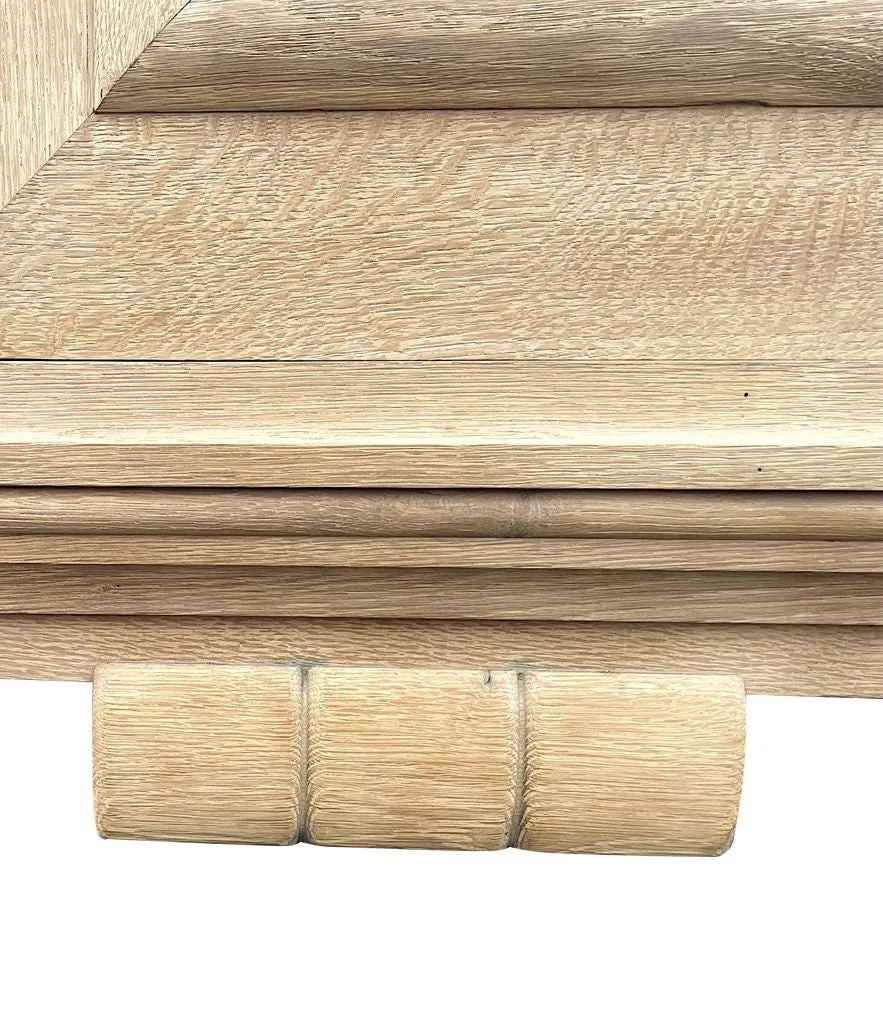A French 1940s bleached oak sideboard in the style of Charles Dudouyt with two doors and four central drawers and relief front design
